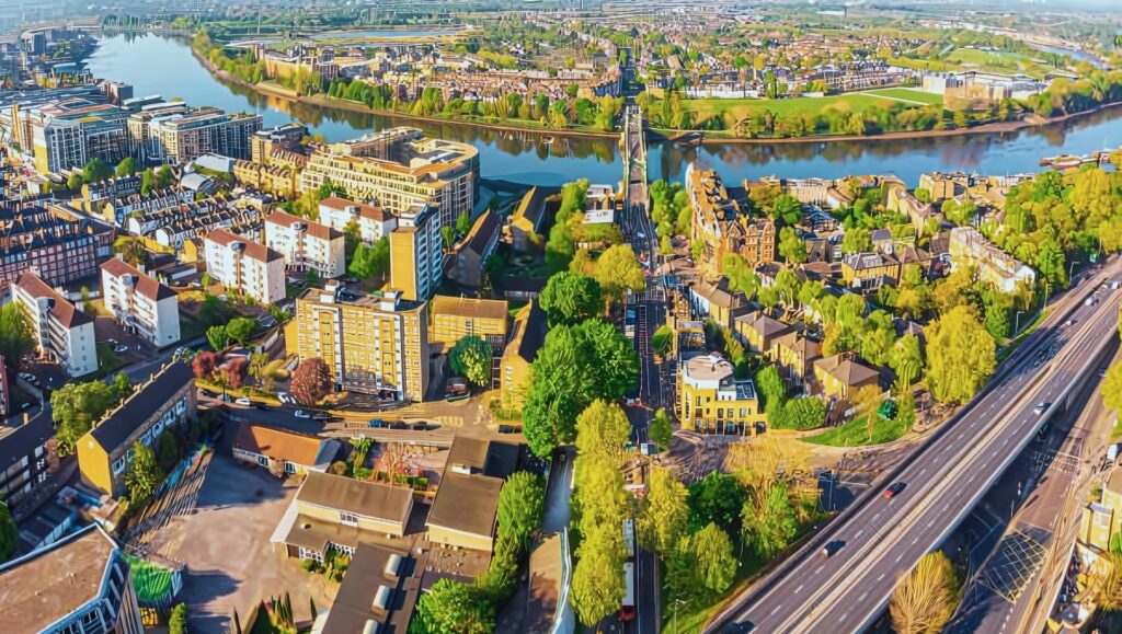 Aerial view of Hammersmith, London with the Thames River and urban skyline.